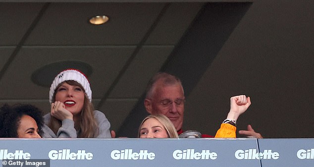 Along with a gray sweatshirt that supported her beau's team, the Grammy winner also donned a white and red-striped beanie that contained a fluffy, brown ball at the top as well as the number 87 stitched in black