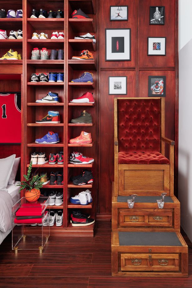 A chair mounted to the wall with sneakers next to it