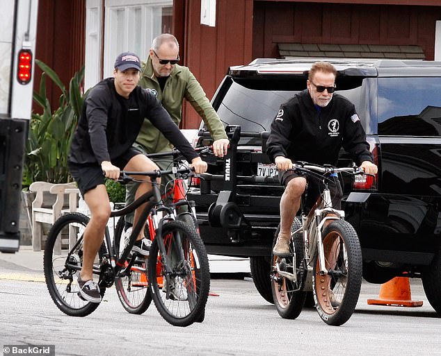 Keeping active: Arnold enjoyed a bike ride with his son Joseph (left) last week