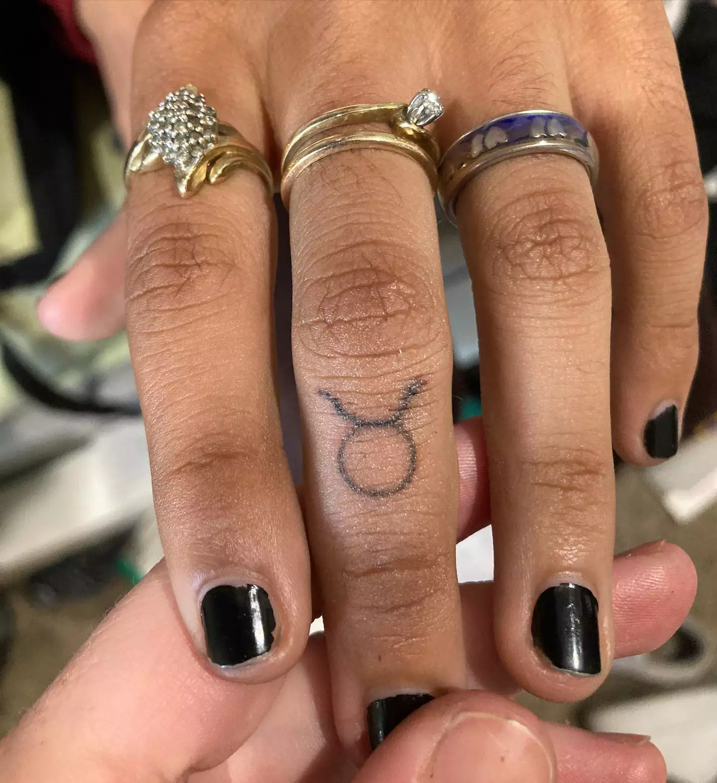 Image of the Taurus sign tattooed on a finger