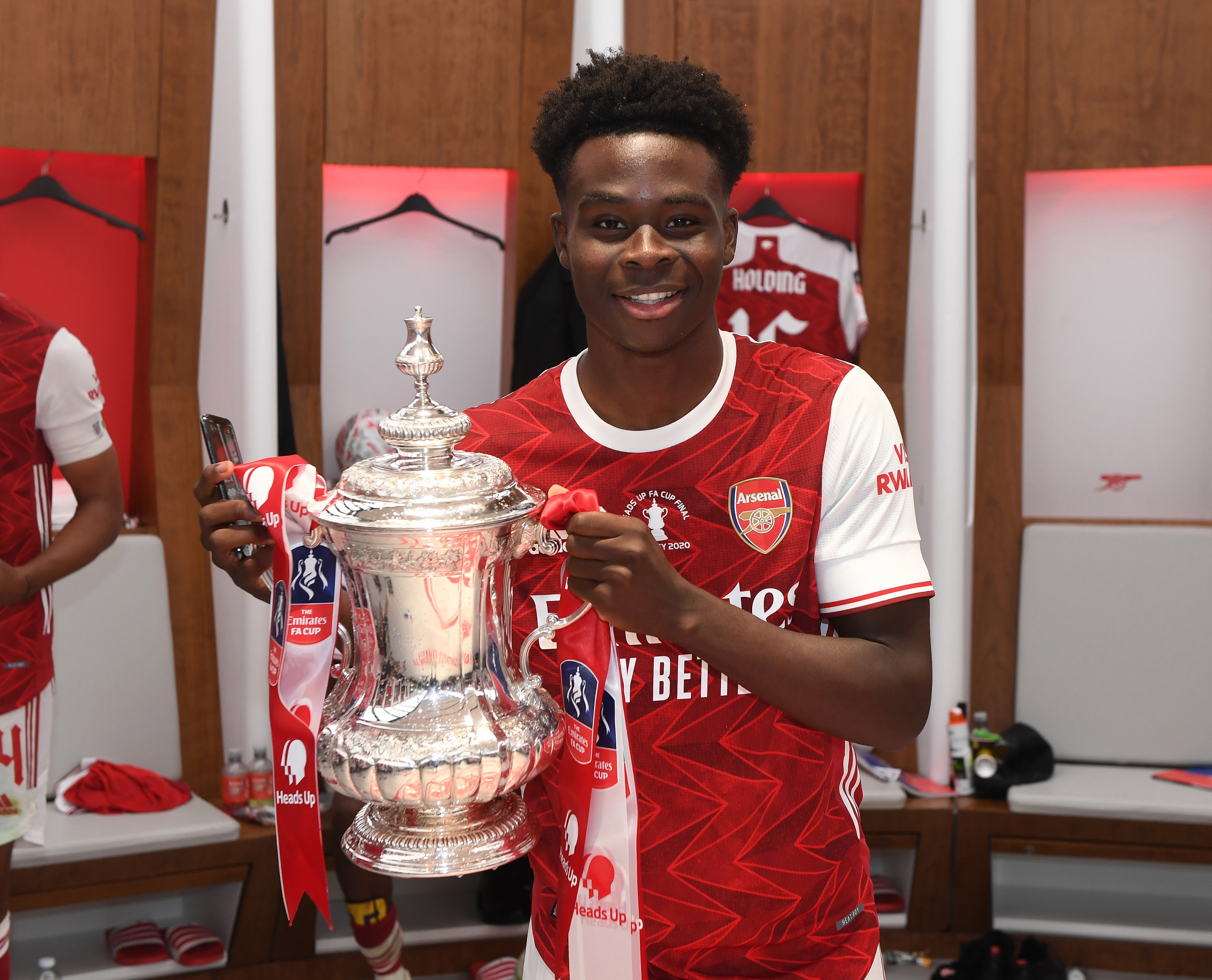 Saka shows off the FA Cup trophy he won with Arsenal in 2020