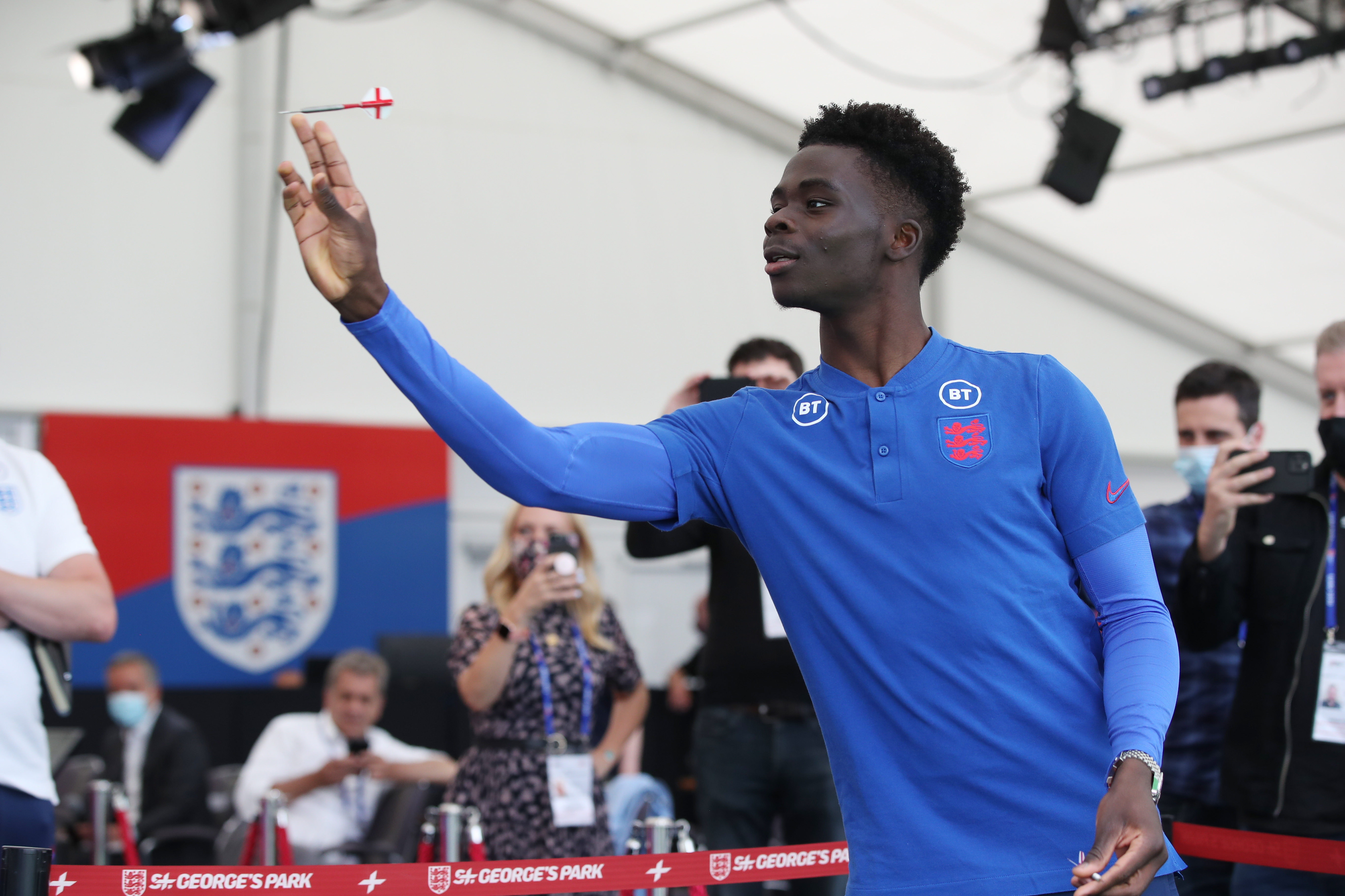 Modest Saka shows off his darts skills during a media day at St George's Park