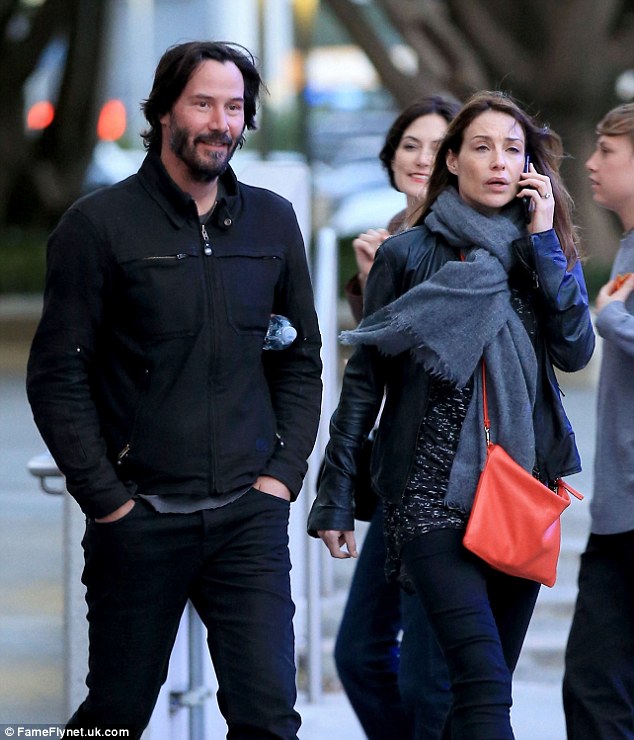 Don't you look dapper: Keanu Reeves looked handsome as he attended a concert in Los Angeles on Wednesday with a gorgeous mystery woman