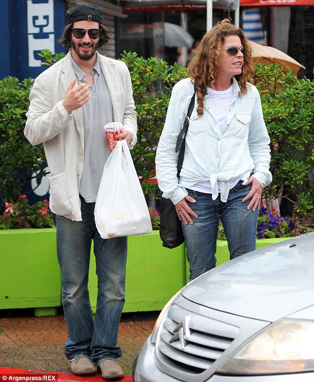 Happy and relaxed: Keanu was relaxing with friends, which went against his occasional solo image