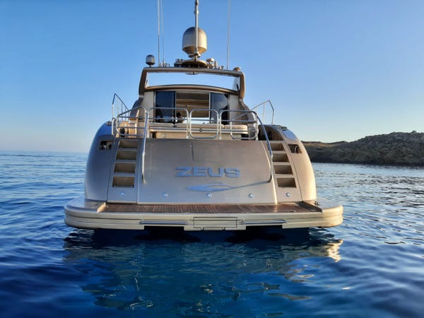 Rear of Zeus yacht floating on water at sunset