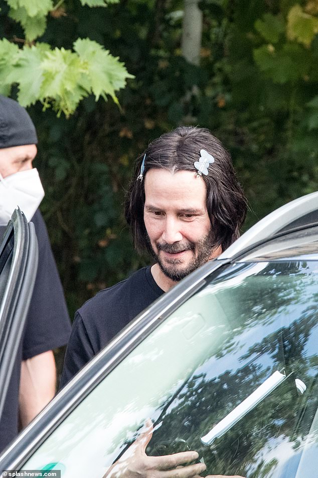 Doing his thing: Keanu Reeves, 56, was rocking a unique style on the set of John Wicks 4 in Berlin, Germany on Monday as he wore clips in his hair at the Claerchen's Ballhaus beer garden