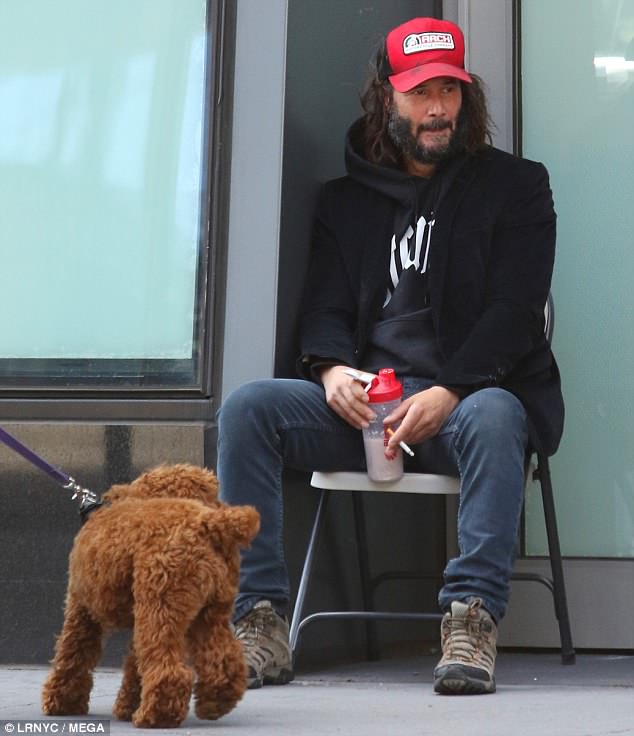 Walkies: A passing dog sniffed at the actor as he took the weight off his feet during  a break on Thursday 