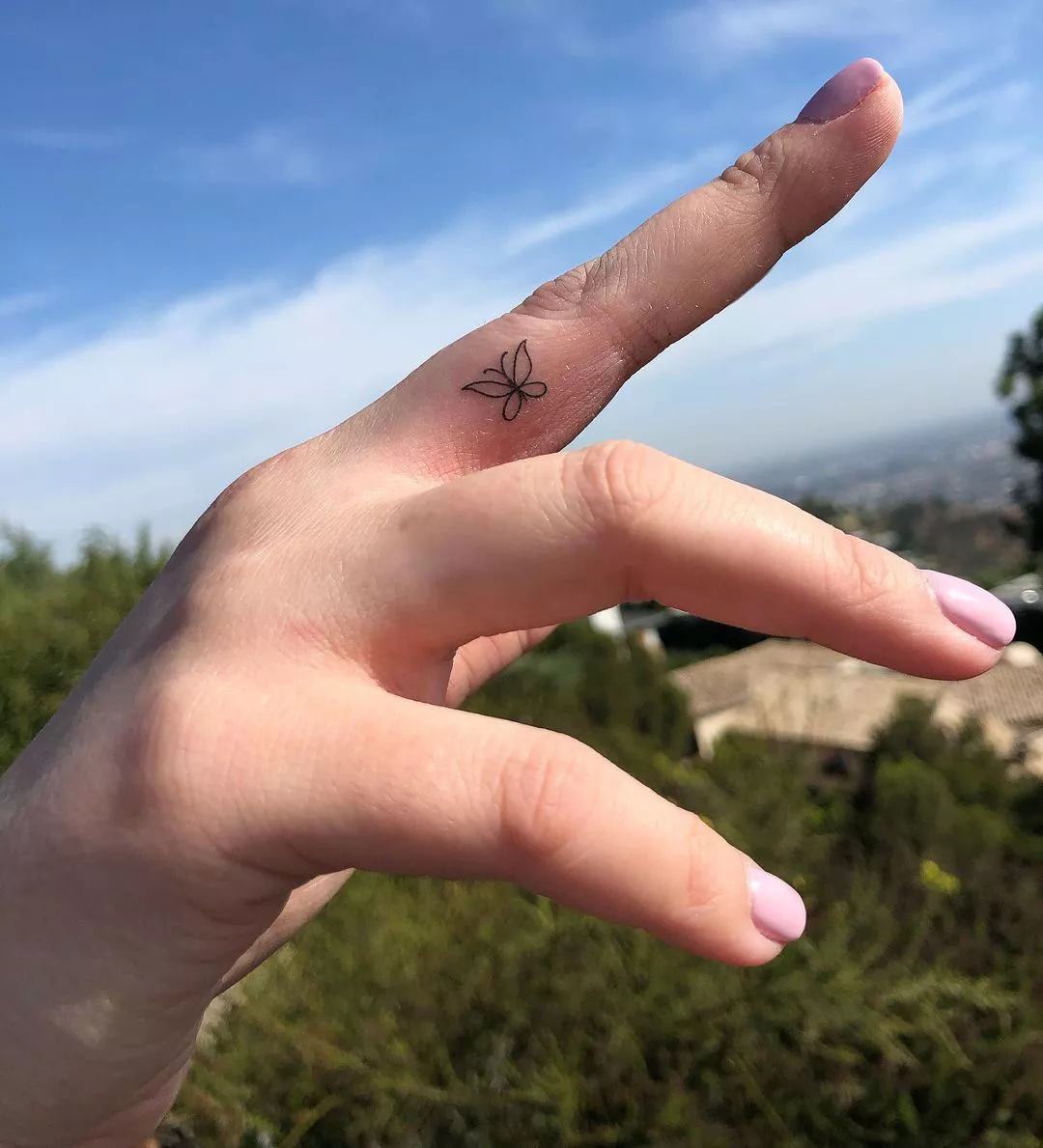 Close up of a simple line design butterfly on the middle finger