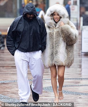 A hood on the outer piece was propped up on top of her head to protect her hair from the cold rain