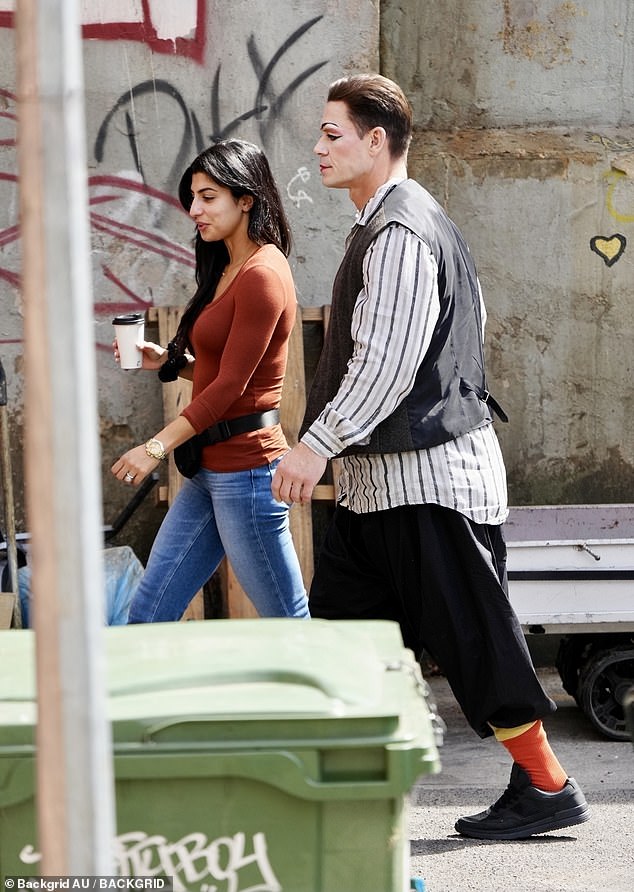 Under wraps: He also donned baggy vest, button down-striped shirt, and shorts combination which concealed his very muscular figure