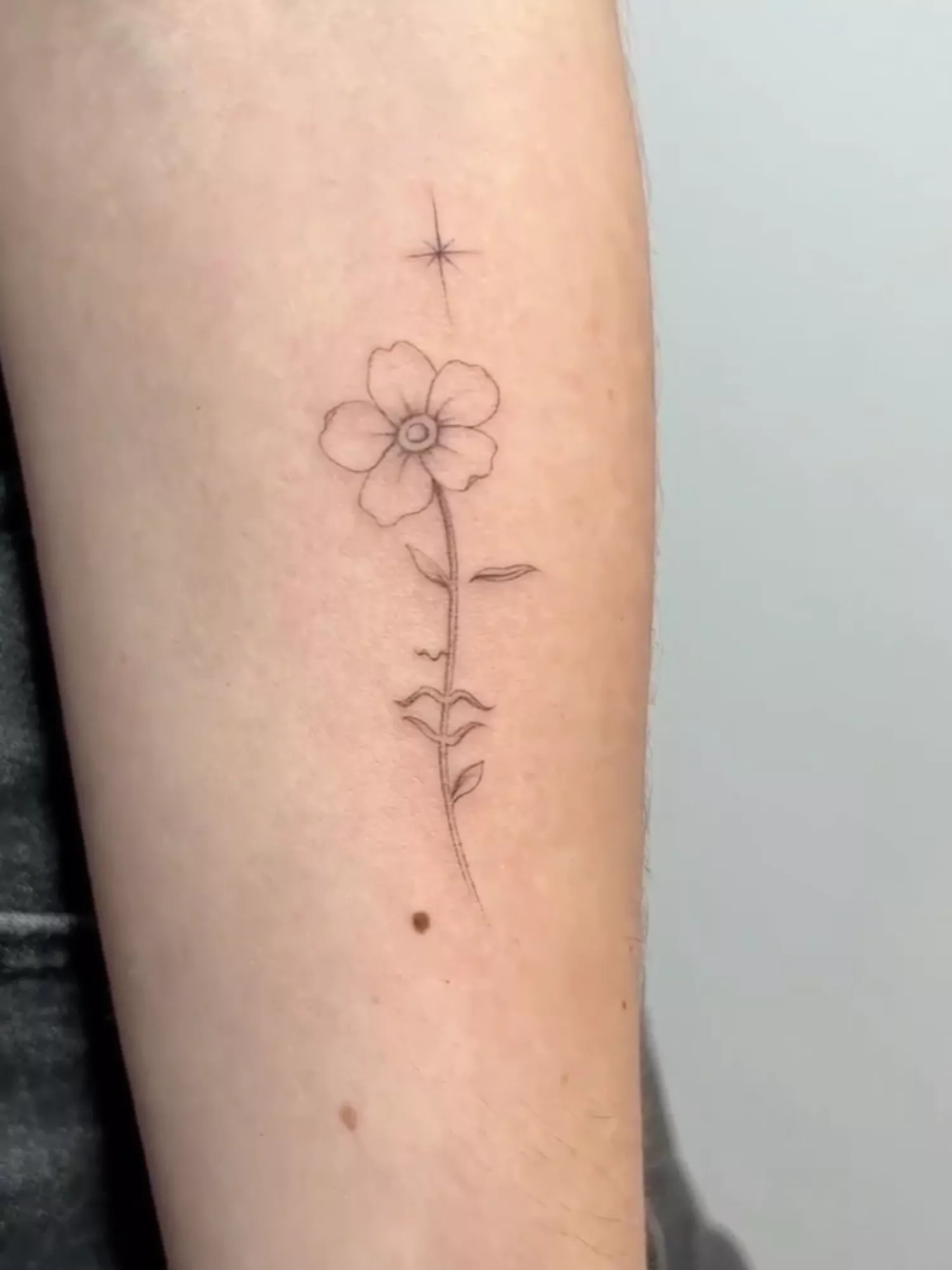 forearm with flower tattoo