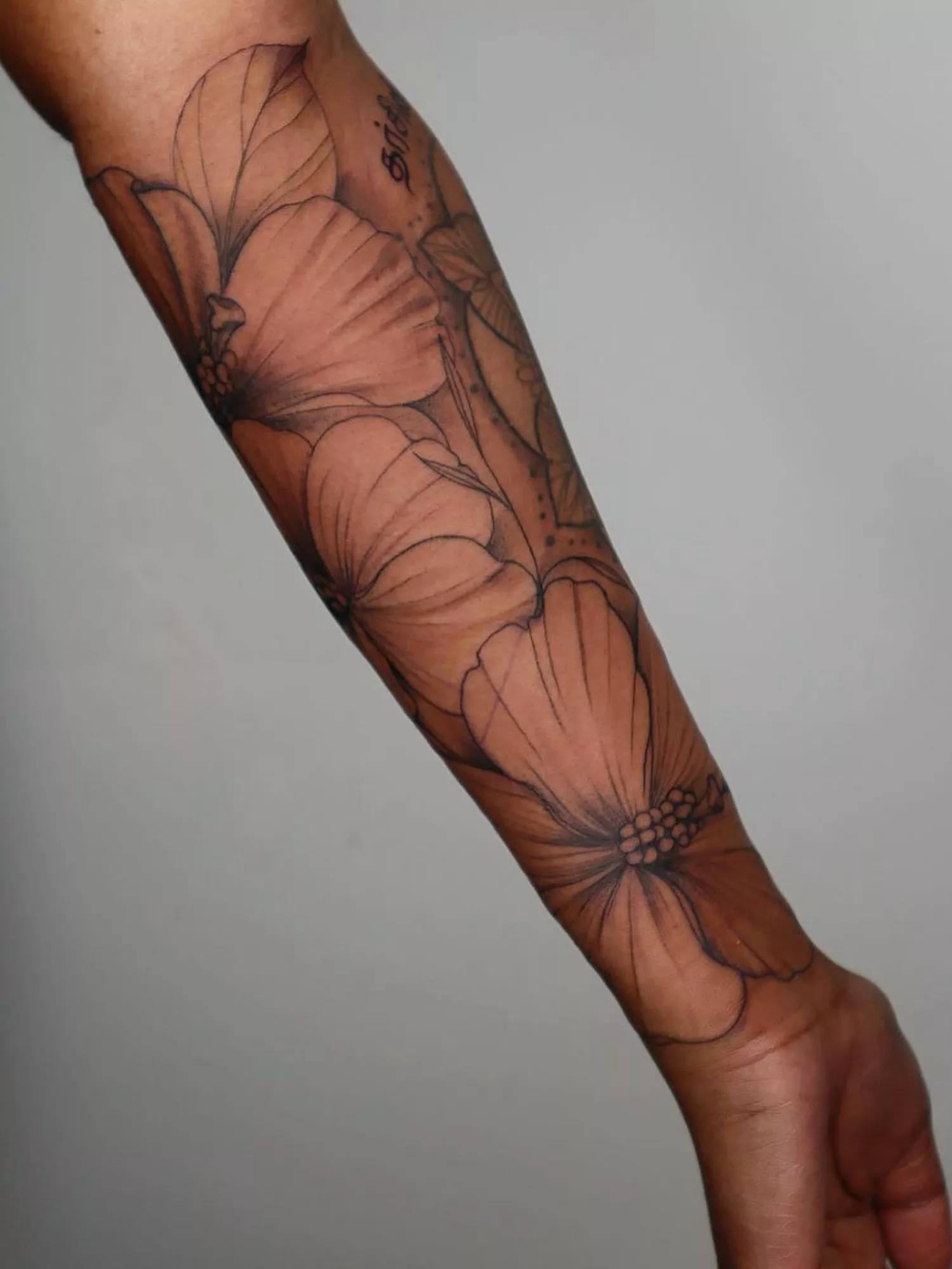 forearm with flower tattoo