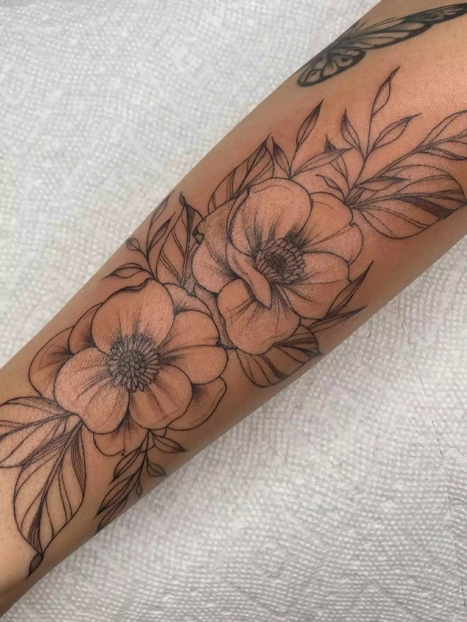 forearm with flower tattoo