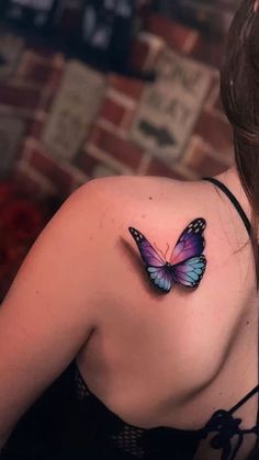 This may contain: a woman with a butterfly tattoo on her shoulder