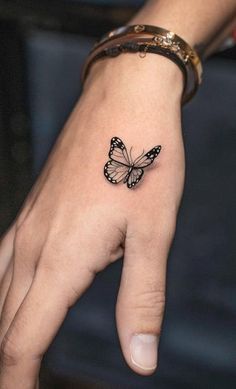 This may contain: a small butterfly tattoo on the left hand