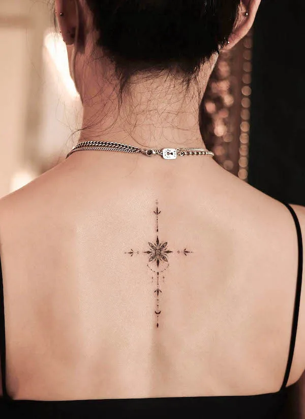 Tiny symbolic cross on the spine by @sukza__art