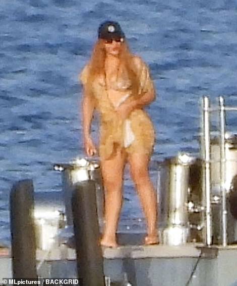 There she is: The R&B legend revealed her curves in a light coloured bikini, worn beneath a delicate sheer wrap as she gingerly climbed aboard the waiting jet-ski