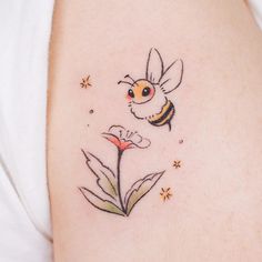 This contains: Flowers and lovely colorful bee tattoo