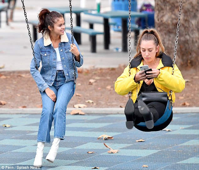 Play date: While accompanied by her assistant, the two were seen having fun on the swings together at a local park