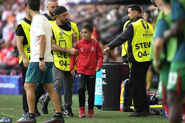 The child initially dodged several attempts from guards who were trying to get the fan off the pitch so play could resume