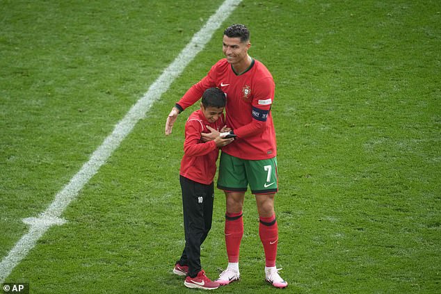 Cristiano Ronaldo poses for selfie with young fan during Portugal's win over Turkey at Euro 2024 but frustrated superstar rejects FOUR more requests from pitch invaders, sparking security concerns | Daily Mail Online