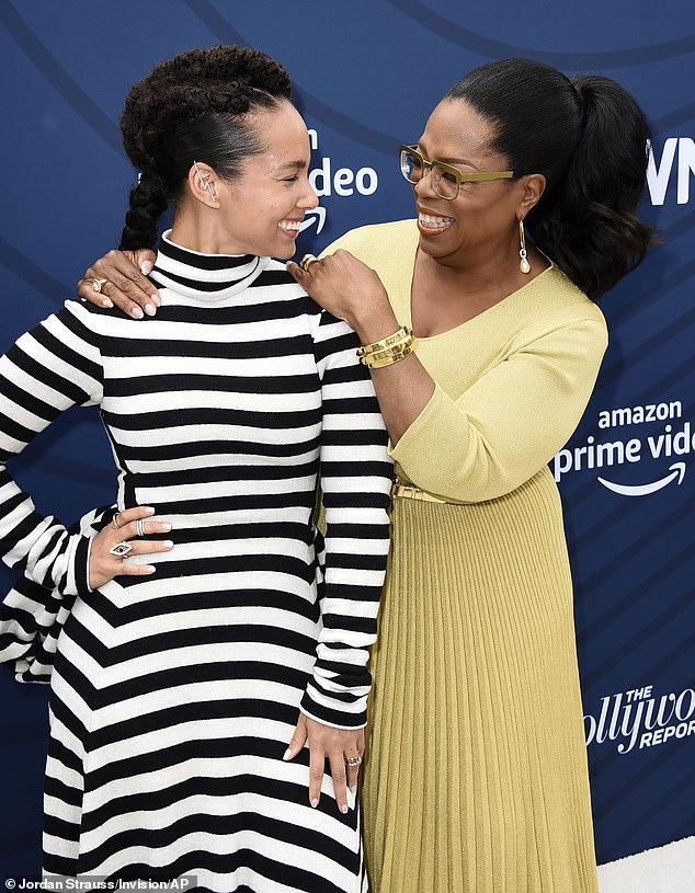 Pals: She posed for photos on the white carpet with Oprah who wore a mustard yellow woolen dress with shiny gold heels and spectacles that matched the color of her outfit