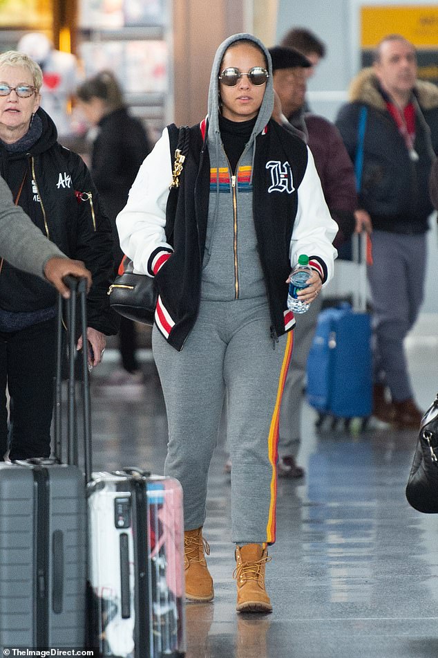 Staying hydrated: Alicia carried a bottle of mineral water as she strolled through the airport, all bundled up in Aviator Nation to ward off the wintry northeastern chill