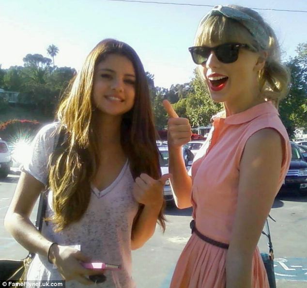 Chilling out: The girls looked relaxed as they posed for fans on their way out of the restaurant, giving the thumbs up to the camera