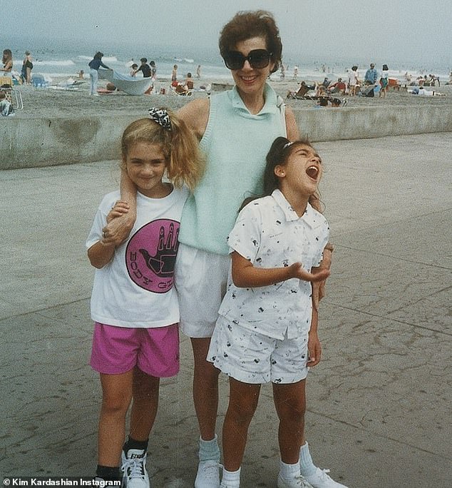 With grandma MJ: In the duo of throwback snaps, Kim, now 39, is in a white patterned short and pants set, with a matching white hair tie keeping her very high ponytail in place