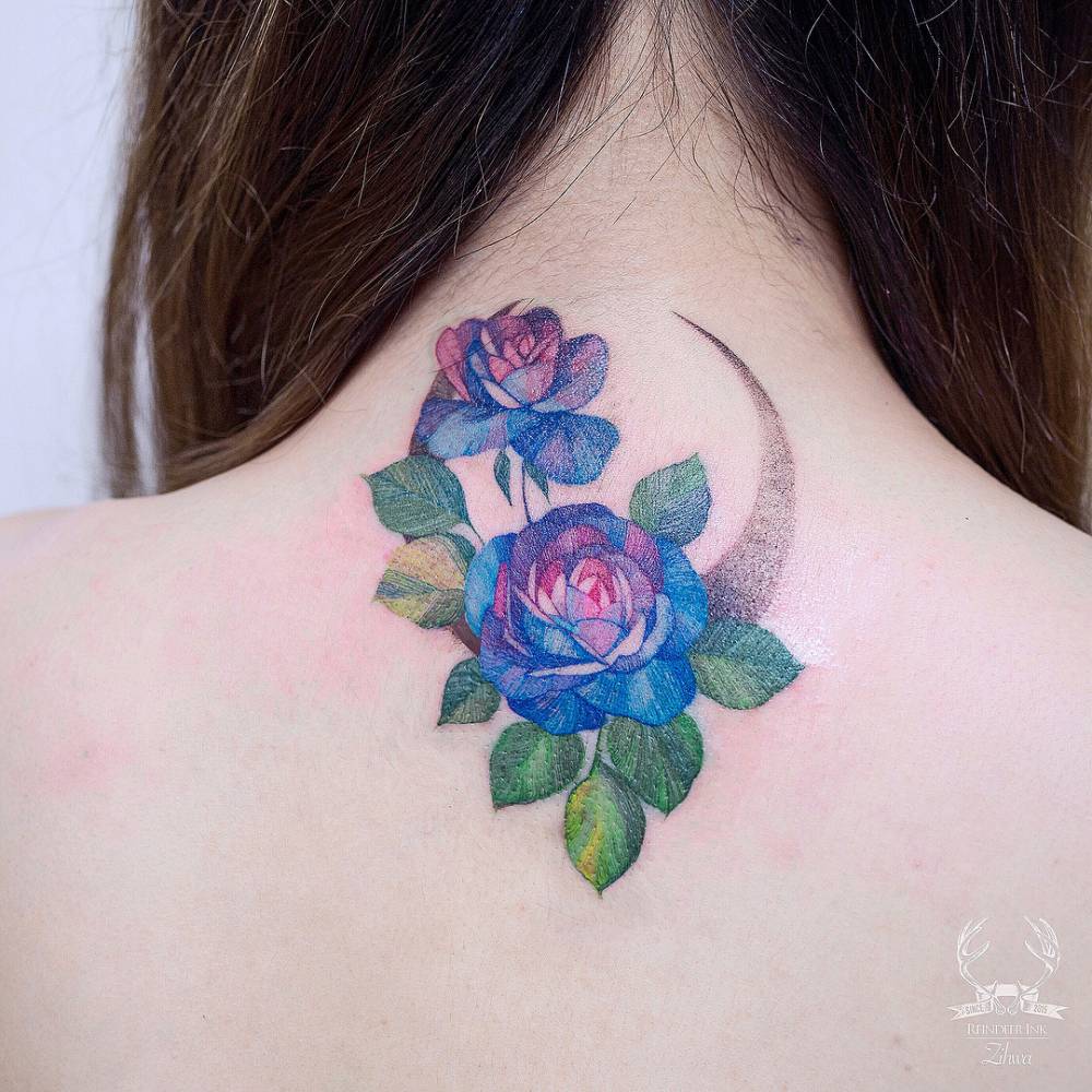 Blue rose and moon tattoo on the upper back.